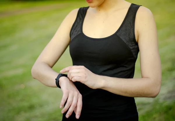 Una joven usa un rastreador de fitness. Smartwatch. . — Foto de Stock