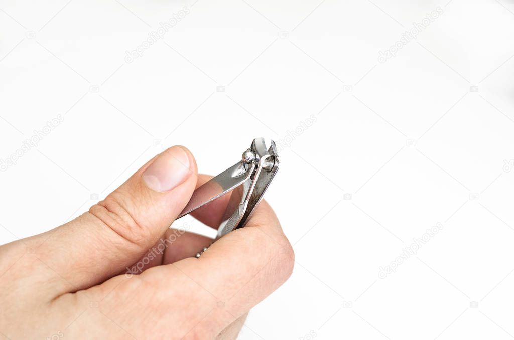 Young man holding a nail clipper tool.