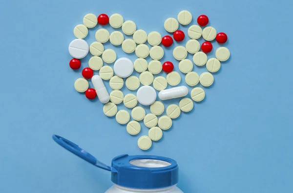 White heart pills on a colored background.