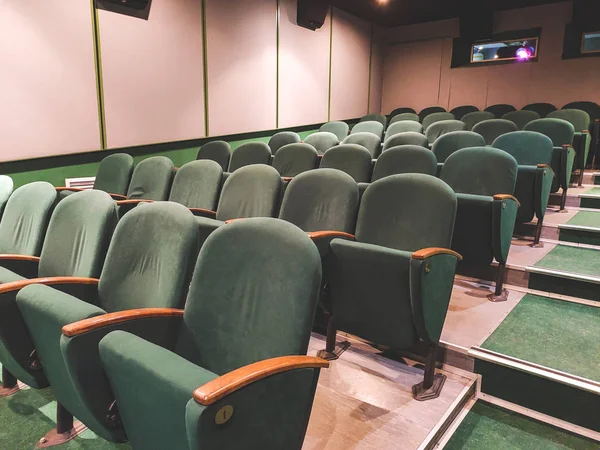 Empty old movie theater. Green armchairs. Waiting for visitors.