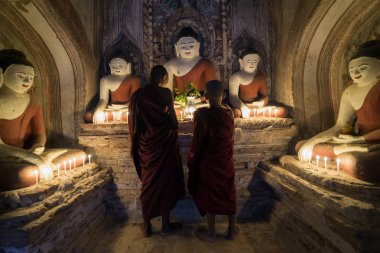 İki acemi Budist rahip, Eski Bagan'ın birçok antik tapınağından biri olan Myanmar'da dua ediyor (Burma)