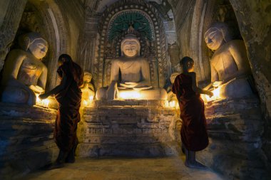 İki acemi Budist rahip, Eski Bagan'ın birçok antik tapınağından biri olan Myanmar'da dua ediyor (Burma)