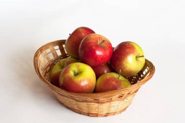 Beyaz arka planda izole hasır sepet kırmızı ve sarı elma