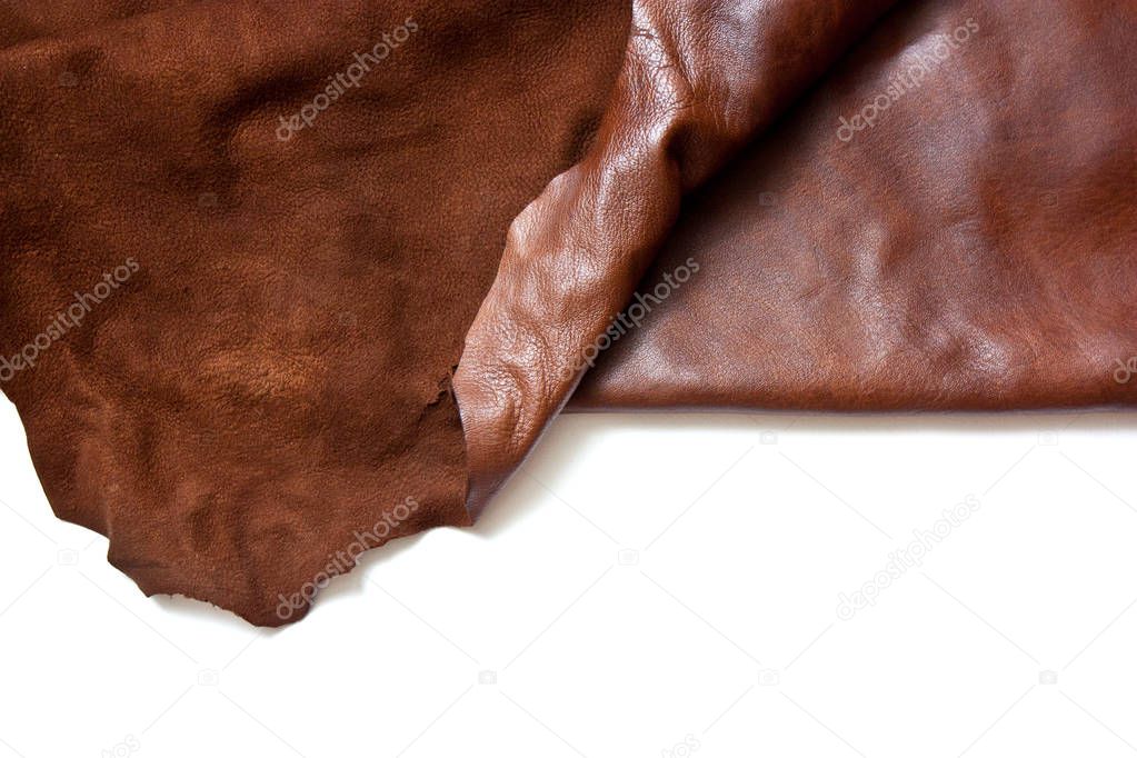 Piece of natural brown leather. Materials for leather craft. Copy space. Top view. Handmade craft. Isolated in white