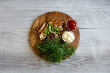 Domatesli ızgara domuz eti ve ahşap tabakta mayonez.