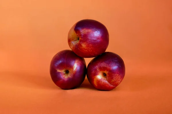 Rode Nectarines Perziken Een Oranje Achtergrond — Stockfoto