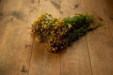 Tahta bir arka planda tıbbi hiperikezi buketi sarı çiçekleri.