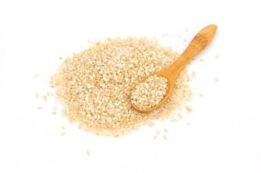 Beyaz arkaplan görünümünde izole edilmiş tahta kaşıkta susam tohumları.
