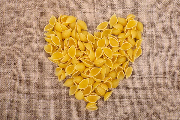 Raw Pasta with ingredients on linen or jute sacking or fabric