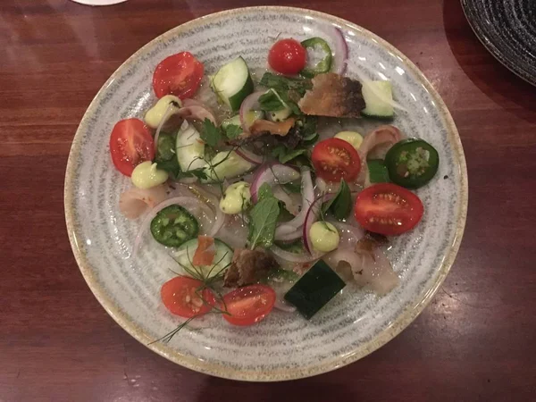 Fluke crudo with peppers tomatoes and dried fish skin