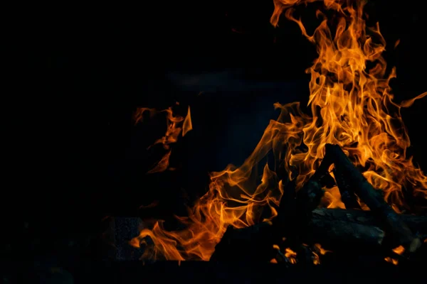 黒を背景に炎が燃える 火は燃焼すると無限大の形を作り出す 炎と黒の背景からのオレンジは興味深いテクスチャを作成します 地獄からの炎だ 燃焼力 — ストック写真