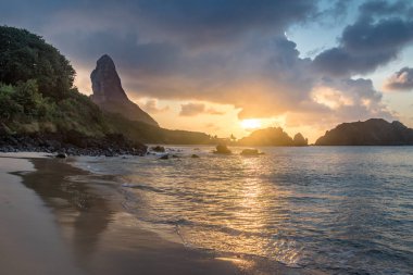Praia do Cachorro Plajı 'nda gün batımında Morro do Pico arka planda Fernando de Noronha, Pernambuco, Brezilya