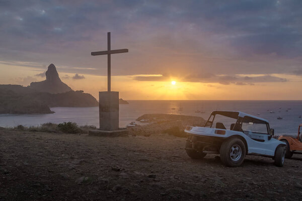 Buggies and Sunset View from Chapel of Sao Pedro dos Pfeladores with Morro do Pico on background - Fernando de Noronha, Pernambuco, Бразилия
