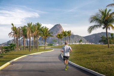 Rio de Janeiro, Brezilya - 25 Ekim 2017: Marina da Gloria parça ve Sugar Loaf Dağı arka plan üzerinde - Rio de Janeiro, Brezilya koşan adam