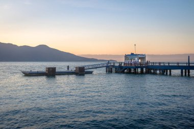 Ilhabela, Brezilya - 10 Eylül 2017: Arka planda Sao Sebastiao ile Ilhabela iskelesinin gün batımı görünümü - Ilhabela, Sao Paulo, Brezilya
