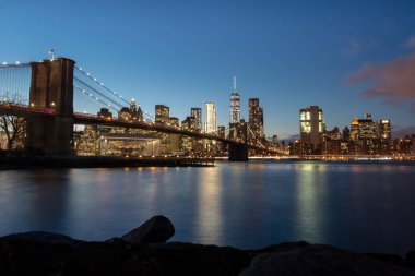 Brooklyn Köprüsü ve Manhattan siluetinin batımında - New York, ABD