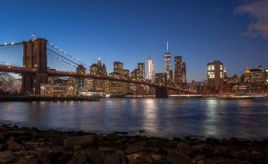 Brooklyn Köprüsü ve Manhattan siluetinin batımında - New York, ABD