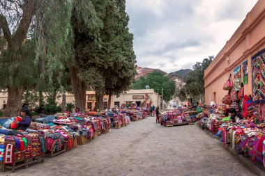 Purmamarca, Jujuy, Arjantin - 26 Nisan 2018: Geleneksel el sanatları giyim beldesi Purmamarca Street - Purmamarca, Jujuy, Arjantin tezgahları