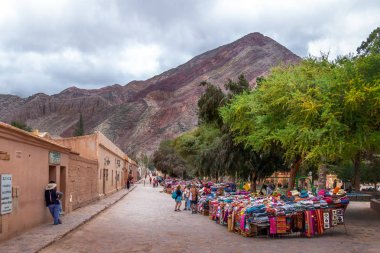Purmamarca, Jujuy, Arjantin - 26 Nisan 2018: Geleneksel el sanatları giyim beldesi Purmamarca Street - Purmamarca, Jujuy, Arjantin tezgahları