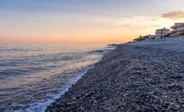 Günbatımı üzerinde bir Akdeniz beach, İyon Denizi Mount Etna Yanardağı ile arka planda - Bova Marina, Calabria, İtalya