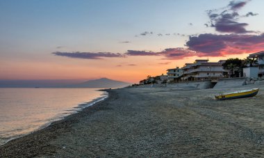 Günbatımı üzerinde bir Akdeniz beach, İyon Denizi Mount Etna Yanardağı ile arka planda - Bova Marina, Calabria, İtalya