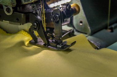 Sarı kumaş ile profesyonel Overlok dikiş makinesi