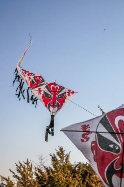 Satır üzerinde açık mavi gökyüzü uçan Çince kağıt uçurtma