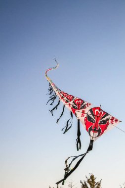 Satır üzerinde açık mavi gökyüzü uçan Çince kağıt uçurtma
