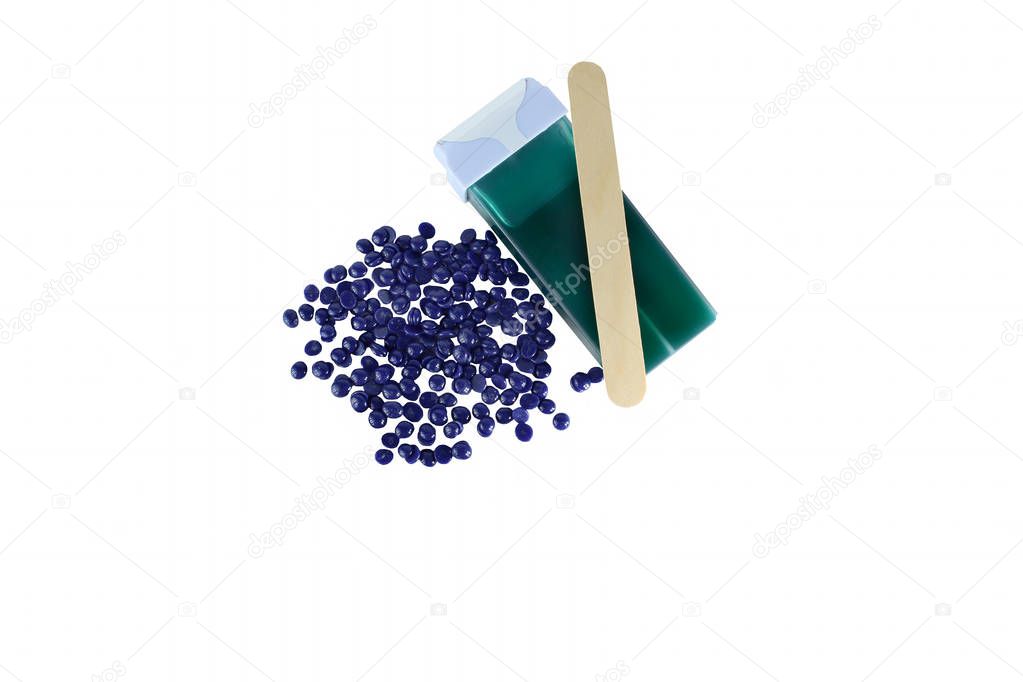 Top view hair removal depilation concept. Green aloe wax cartridge and violet granules with wood spatula isolated on white background. 