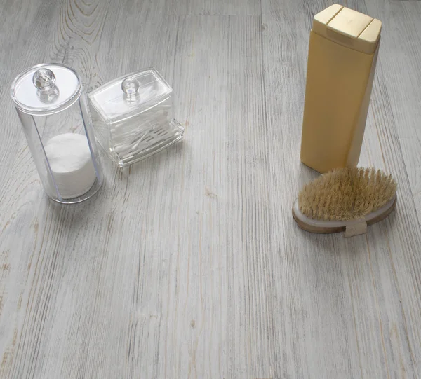 Cosmetic flatlay on grey wooden table. Beauty set of plastic containers with Q-tips and disks. Space for text.