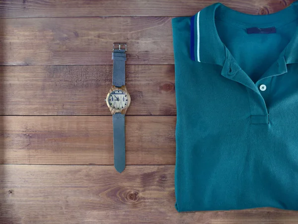 Men flatlyout with polo t-shirt and watch on wooden backround. Set of stylish man clothes and accessories.