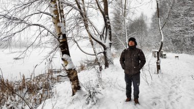 Genç bir adam ormanda gölün yanında tek başına duruyor. Erken bulutlu bir sis günü. Kendinle baş başa kalmak için. Dar sis.