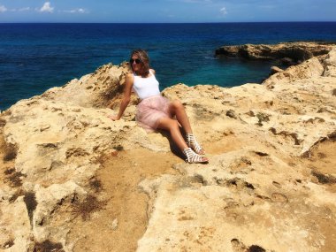 Kıbrıs, Mayıs 2018, Protaras. Deniz kıyısı buzlu bir kız, çok güzel eteği, Rüzgar esiyor