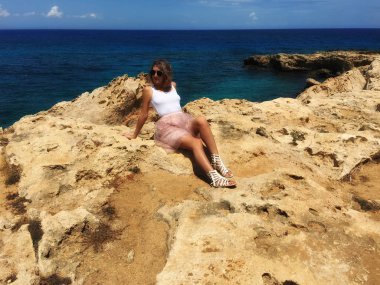 Kıbrıs, Mayıs 2018, Protaras. Deniz kıyısı buzlu bir kız, çok güzel eteği, Rüzgar esiyor