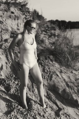 Kız kum üzerinde poz mayo