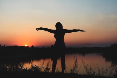 Gün batımında bir kızın silueti