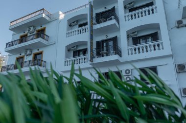 Girit Adası 'nda bir otel. Binanın beyaz cephesinin dışında birçok balkonu var.