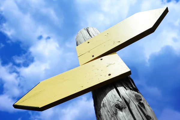 Empty wooden signpost with two arrows