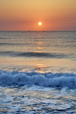 Günbatımı / gündoğumu bir plajda