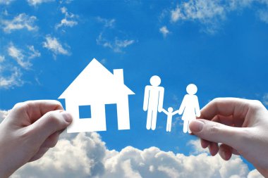 Ev ve aile sigorta kavramı, eller, arka planda gökyüzü
