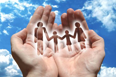 Aile sigortası kavramı, eller, arka planda gökyüzü