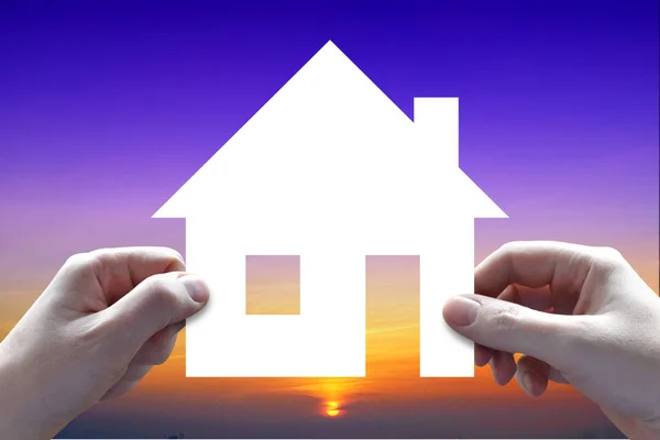 Концепция страхования дома, руки, небо заката на заднем плане — стоковое фото