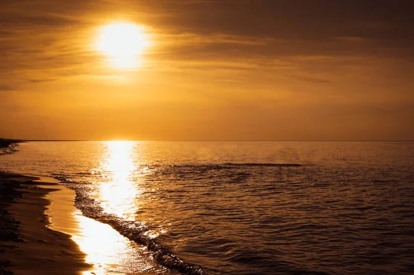 Sunset - sun reflecting in sea / ocean, shore — стоковое фото