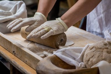 Kadın fırında merdaneyle para kazanıyor.