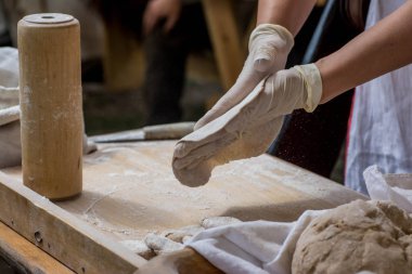 Yakın plan - Tahta tahtada ekmek yapan bir kadının resmi.