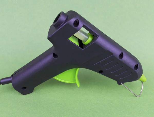 Hot melt gun for plastic soldering on a green background - black with a light green key