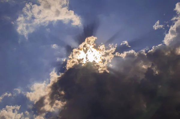 The sun\'s rays break through the clouds in the sky.