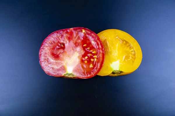 Vegetable red and yellow tomato on a cutting board.