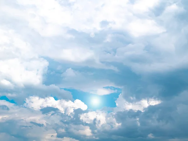 The sun on the background of the cloudy sky. Background image. Sun glare. Camera lens flare. Place for text. Poster. Template. Cloudy landscape. Weather cyclone. Windy weather. Climate change.