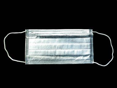 Siyah arka planda beyaz tıbbi maske. Coronavirus. Salgın. Salgın hastalık. Karantinada koruyucu yüz maskesi. Uzaktan kumanda. Virüs hastalığı. Metin için yer.
